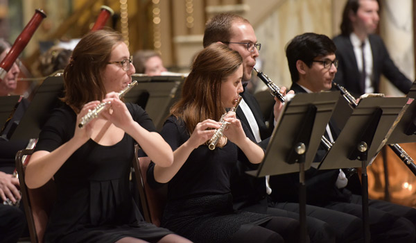  woodwind instrument players performing on stage.